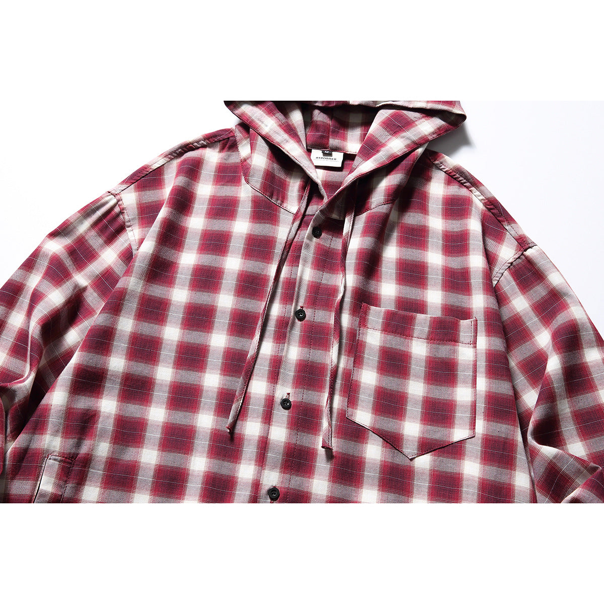 Close-up of a red-and-white plaid hooded button-up shirt with black buttons and a chest pocket.