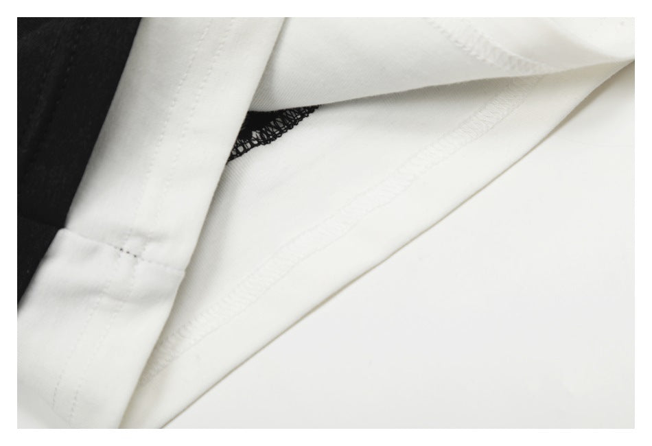 Inside view of white garment fabric showing overlock stitching and a black fabric section.