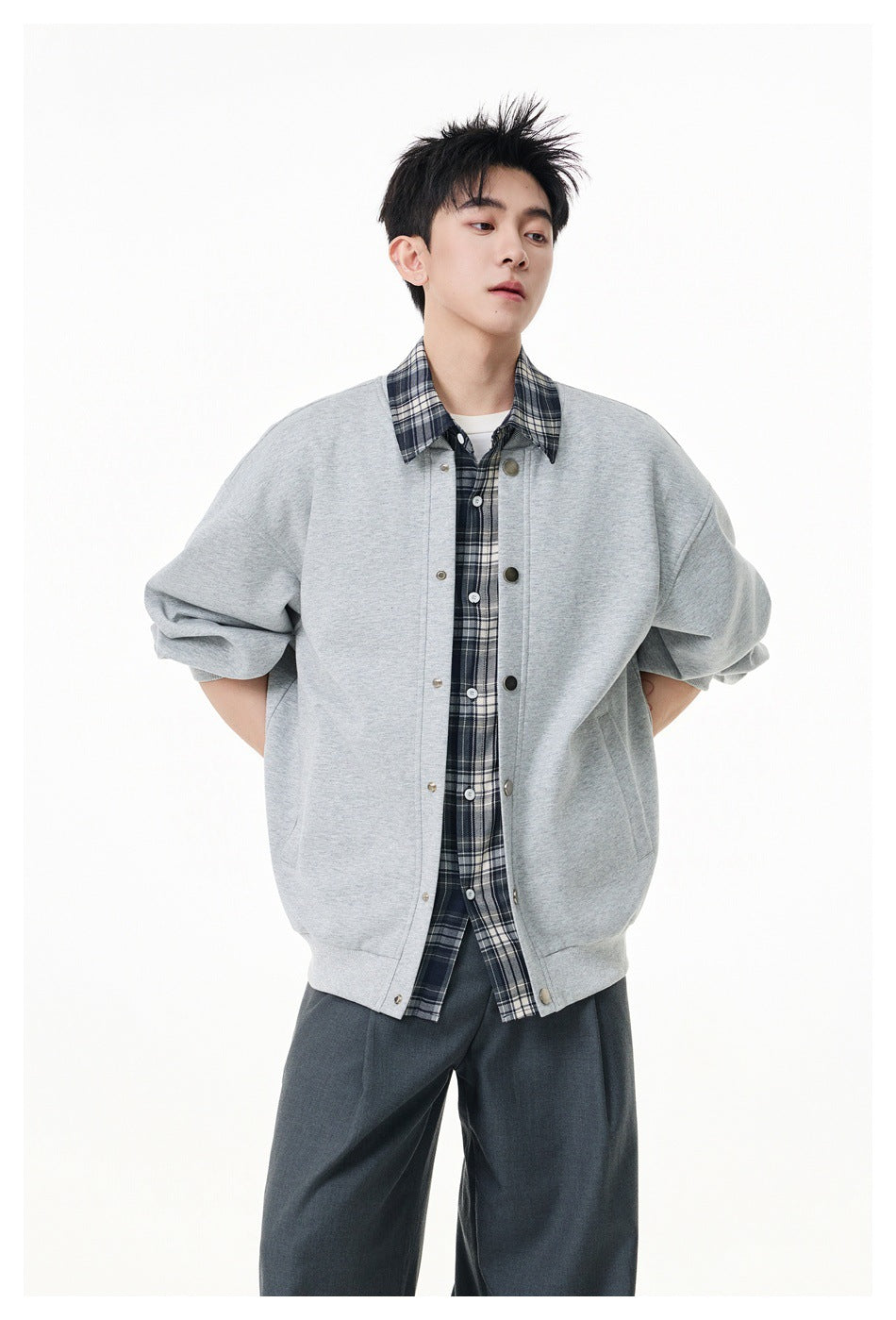 Model wearing a light gray snap-front jacket with a checked collar and placket, shown from the front.