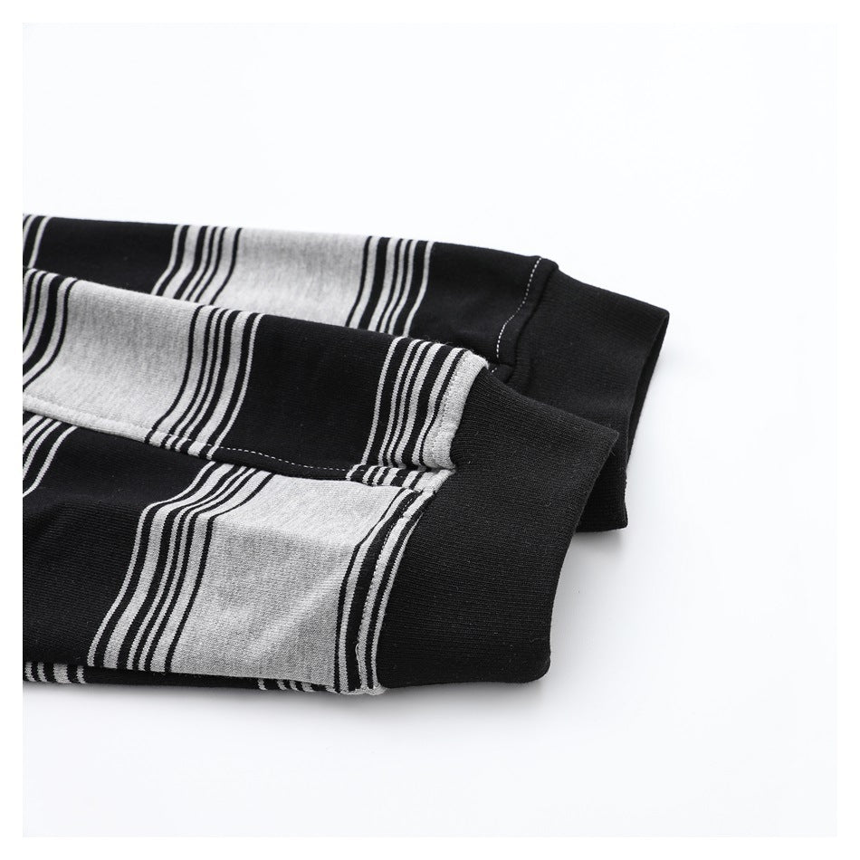 Close-up of black ribbed cuffs on a black and light gray striped long-sleeve shirt.