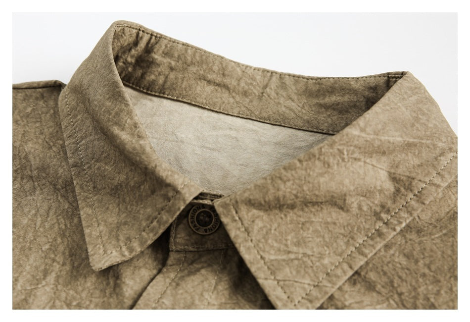 Close-up of the khaki-brown shirt collar, top button, and visibly crinkled surface.