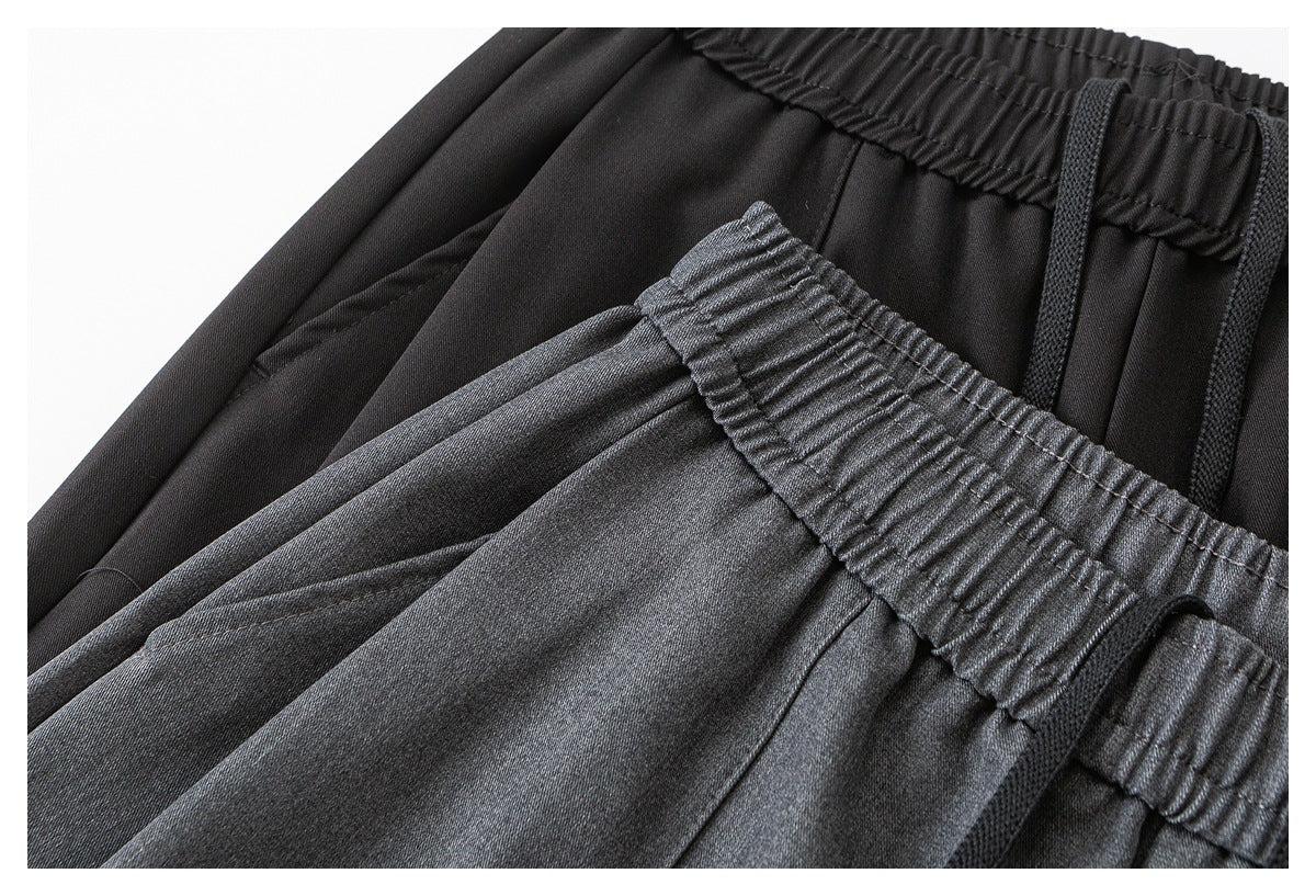 Close-up of dark wide-leg trousers showing the gathered elastic waist and black drawstring.