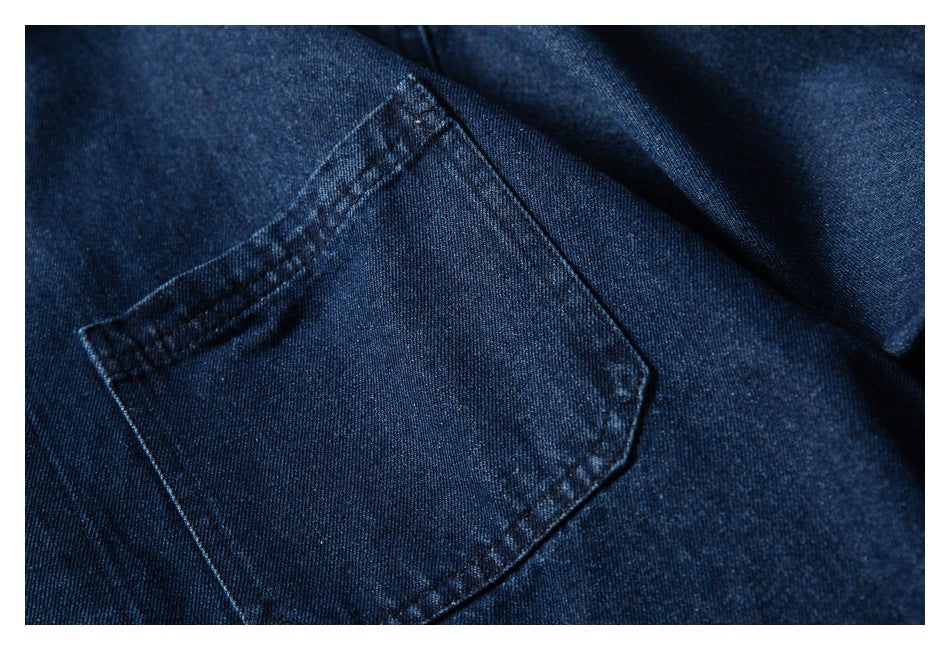 Close-up of a stitched patch pocket on dark blue denim fabric.