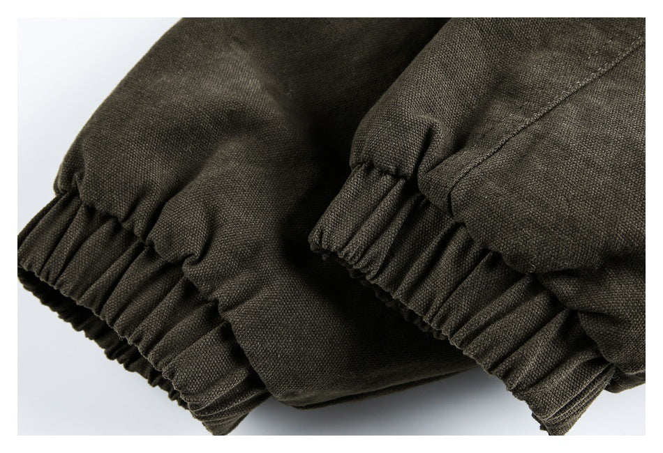 Close-up of dark olive-brown garment sections with gathered elastic cuffs or hems.
