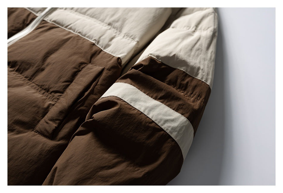 Close-up of a brown and cream color-blocked jacket sleeve and front pocket.