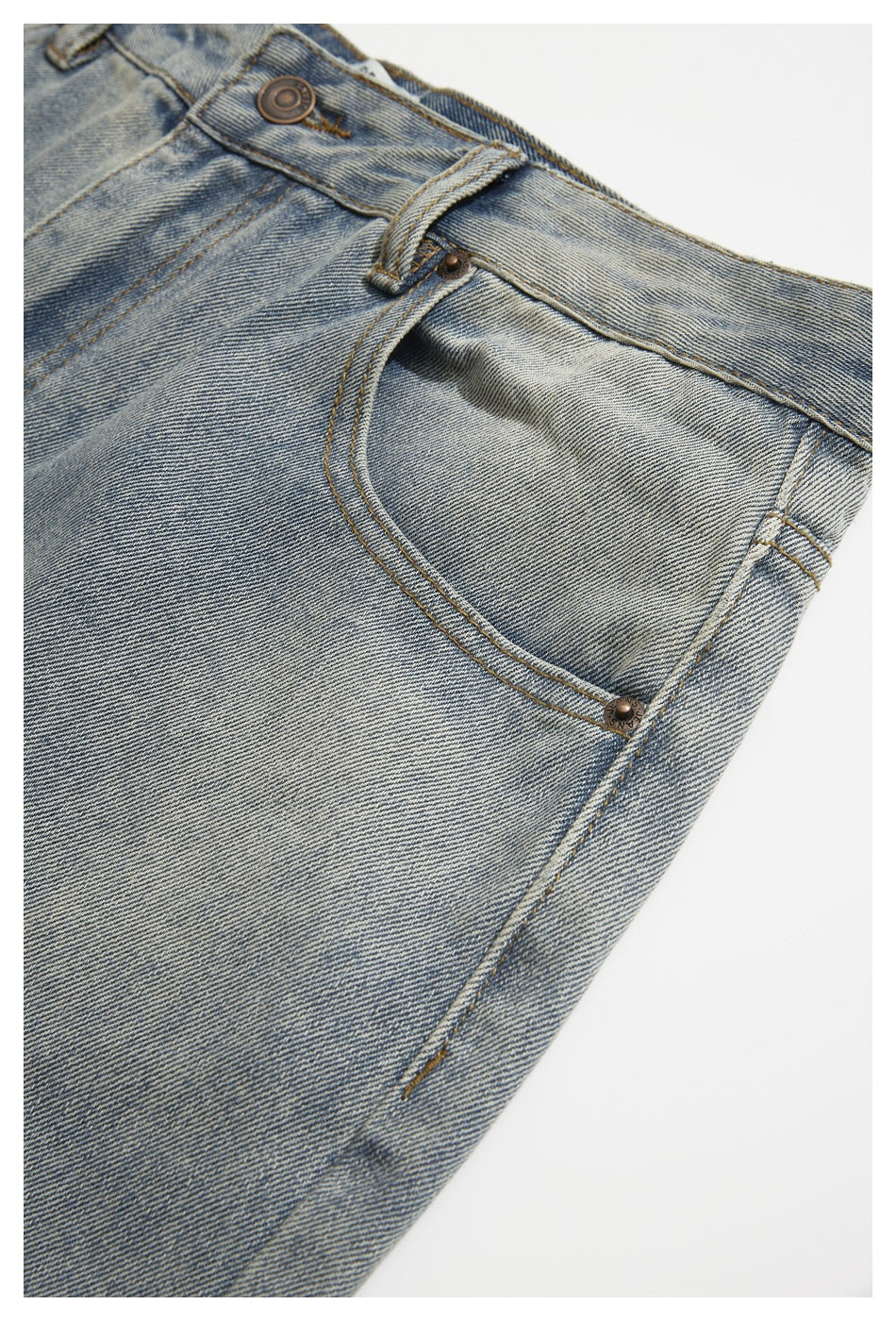 Angled close-up of light blue jeans showing the front pocket, waistband button and belt loop.