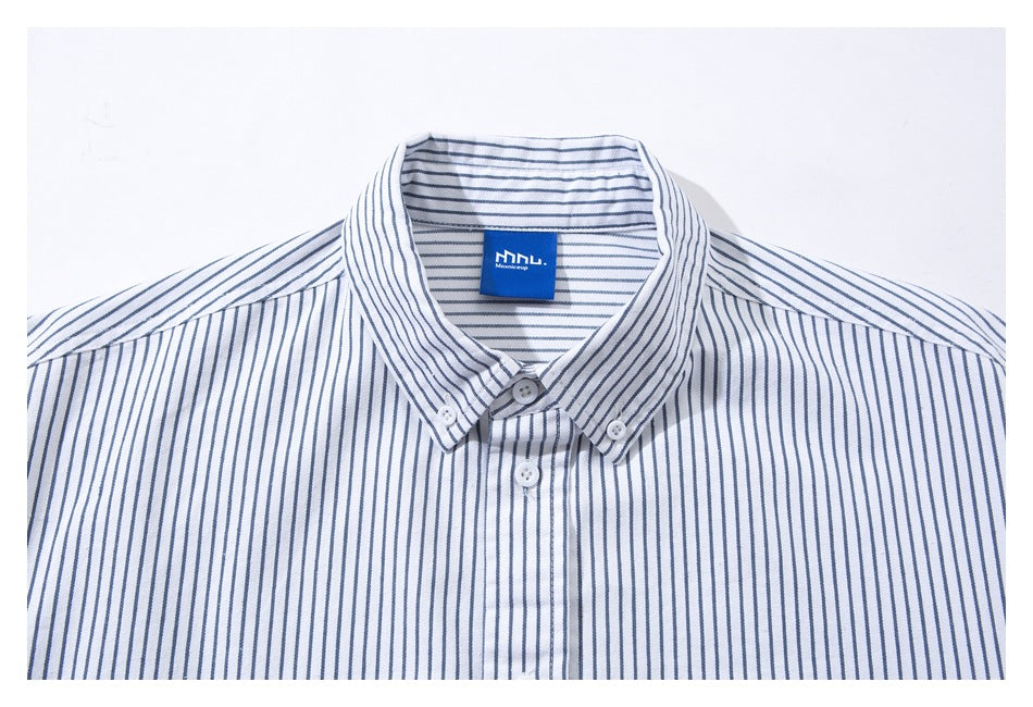 Close-up of a white shirt collar with thin blue vertical stripes, button-down points, and a blue neck label.