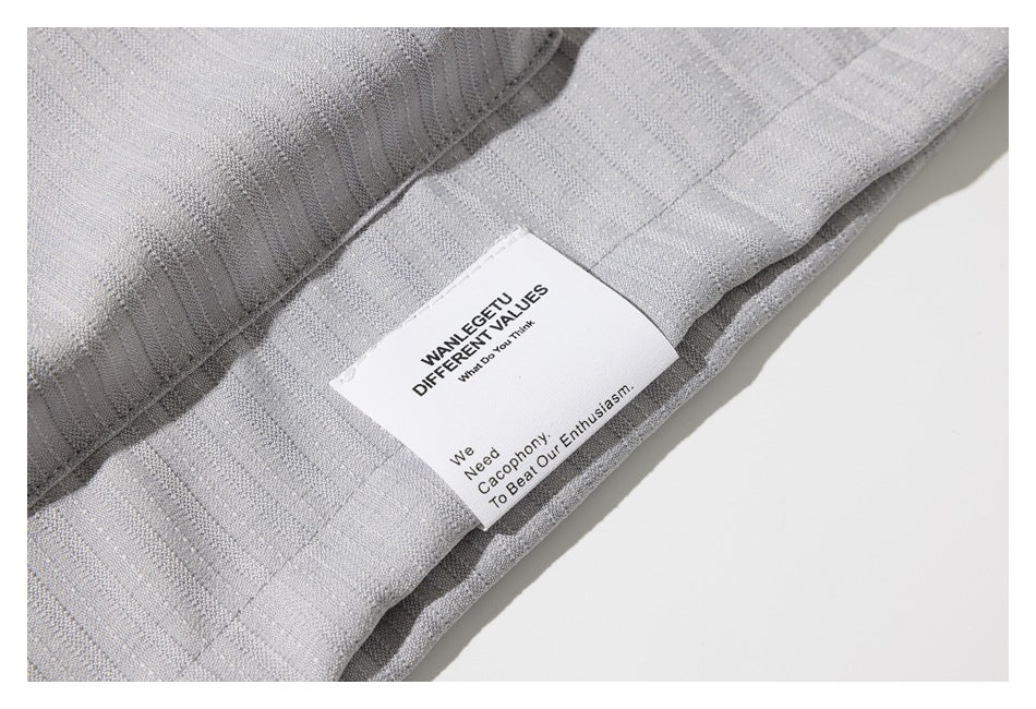 Close-up of light gray striped fabric with a white sewn-in label bearing English text.