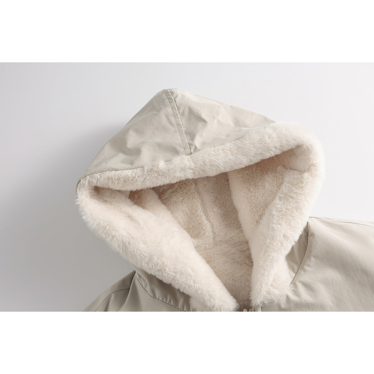 Close-up of a light beige jacket hood with thick cream plush lining and trim.