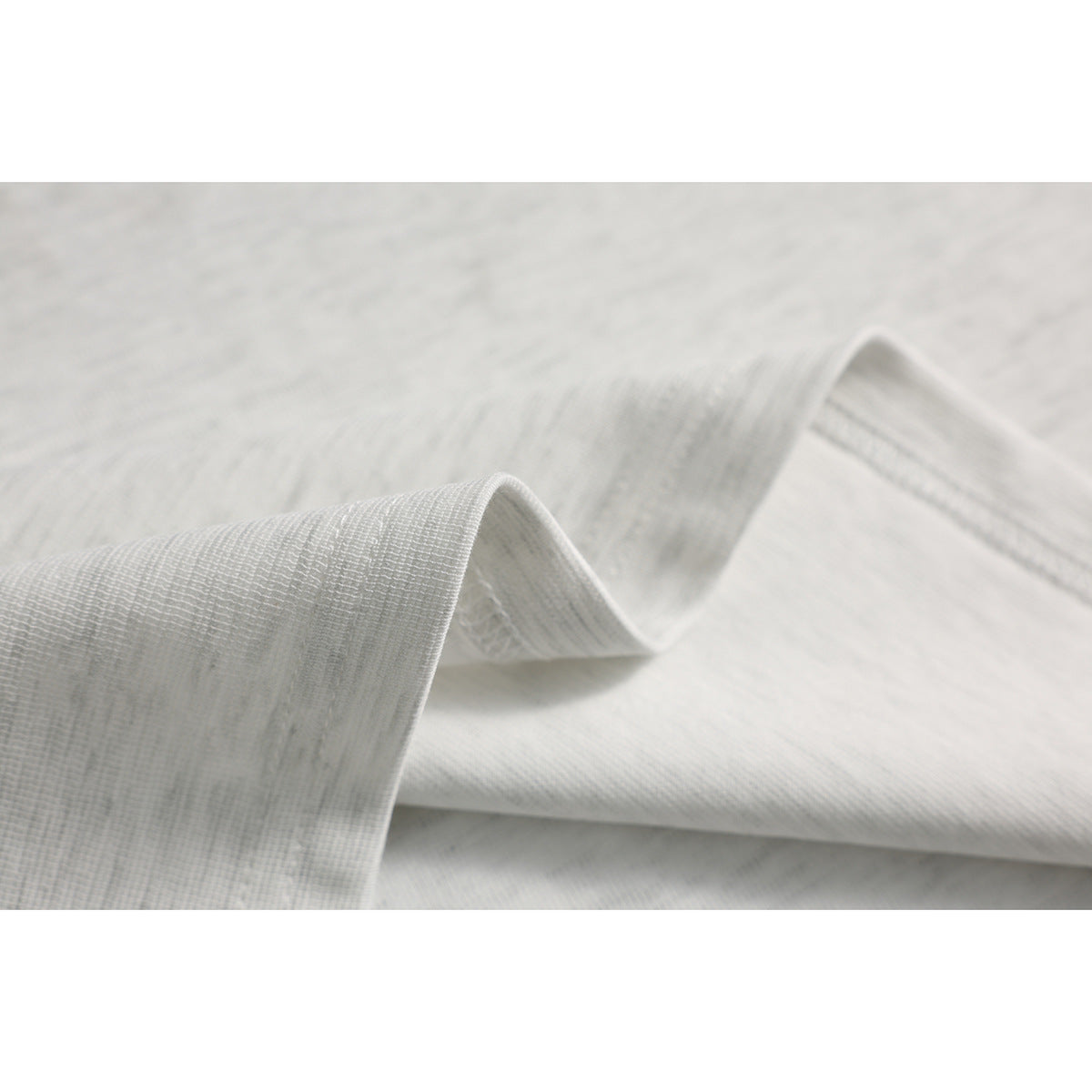 Macro view of pale fabric folded to show its subtle woven texture.