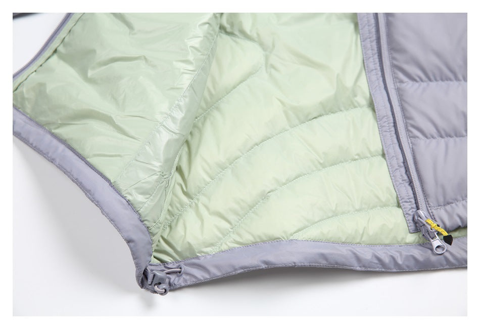 Close-up of a pale green jacket lining, gray trim, zipper, and adjustable hem toggles.