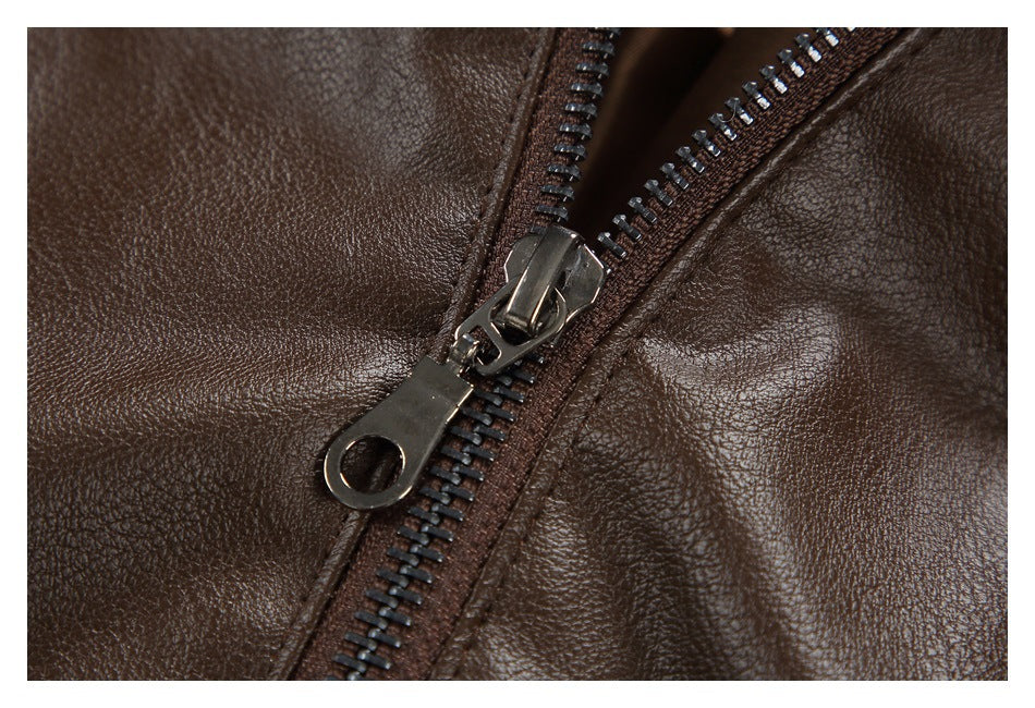Close-up of a dark metal zipper on pebbled brown jacket material.