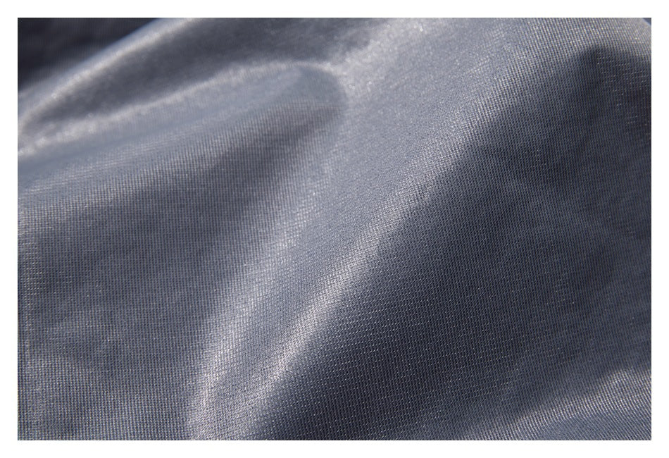 Close-up of shimmering silver-gray fabric with a fine woven texture and soft folds.