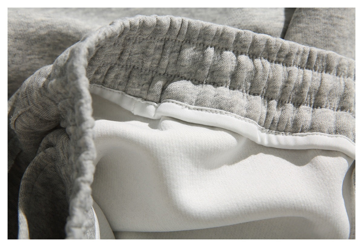 Inside close-up of gray heather shorts showing the elastic waistband seam and white inner lining.