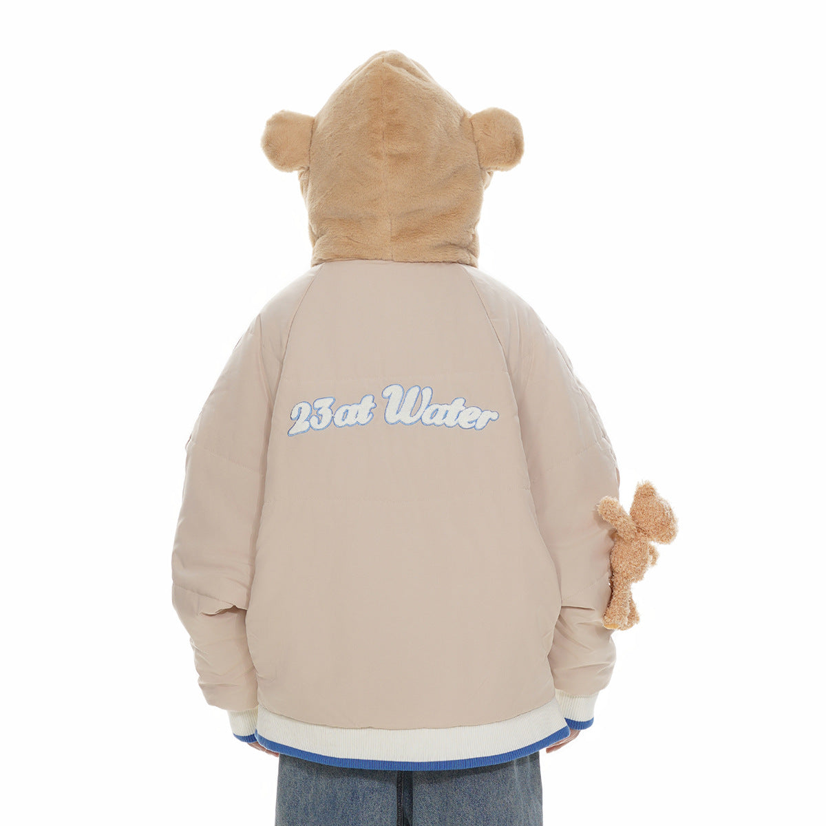 Back view of a beige jacket with a plush bear-ear hood, white-and-blue hem trim, and large embroidered back lettering.
