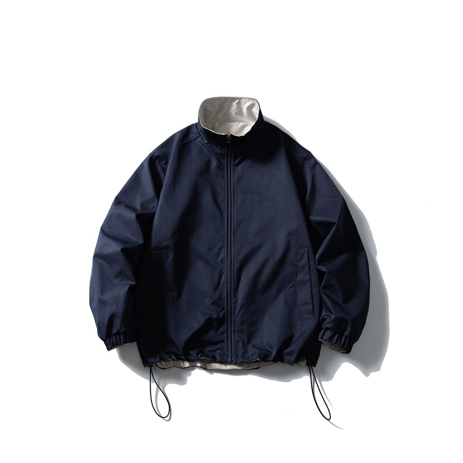 Navy stand-collar zip jacket with light inner collar, elastic cuffs and drawstring hem, flat lay