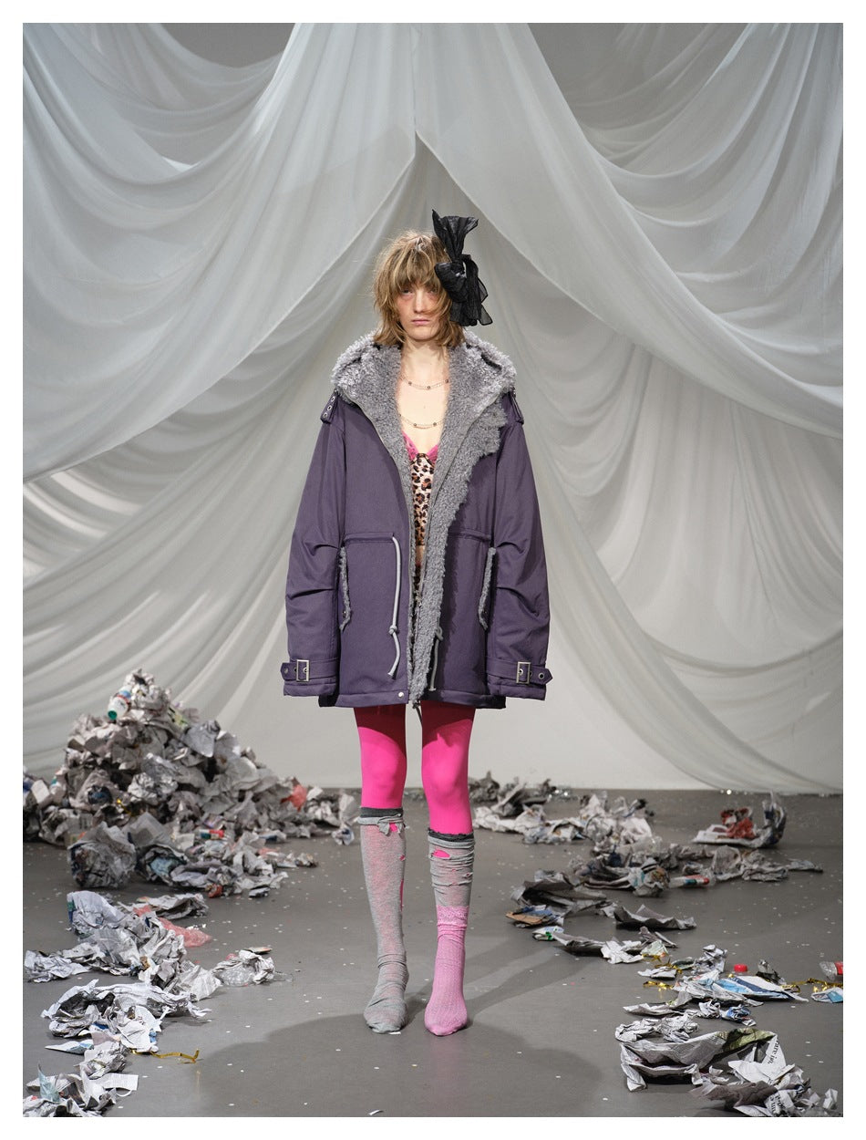 Model wearing an open purple hooded jacket with gray fleece-like lining over a leopard top, pink tights and gray socks