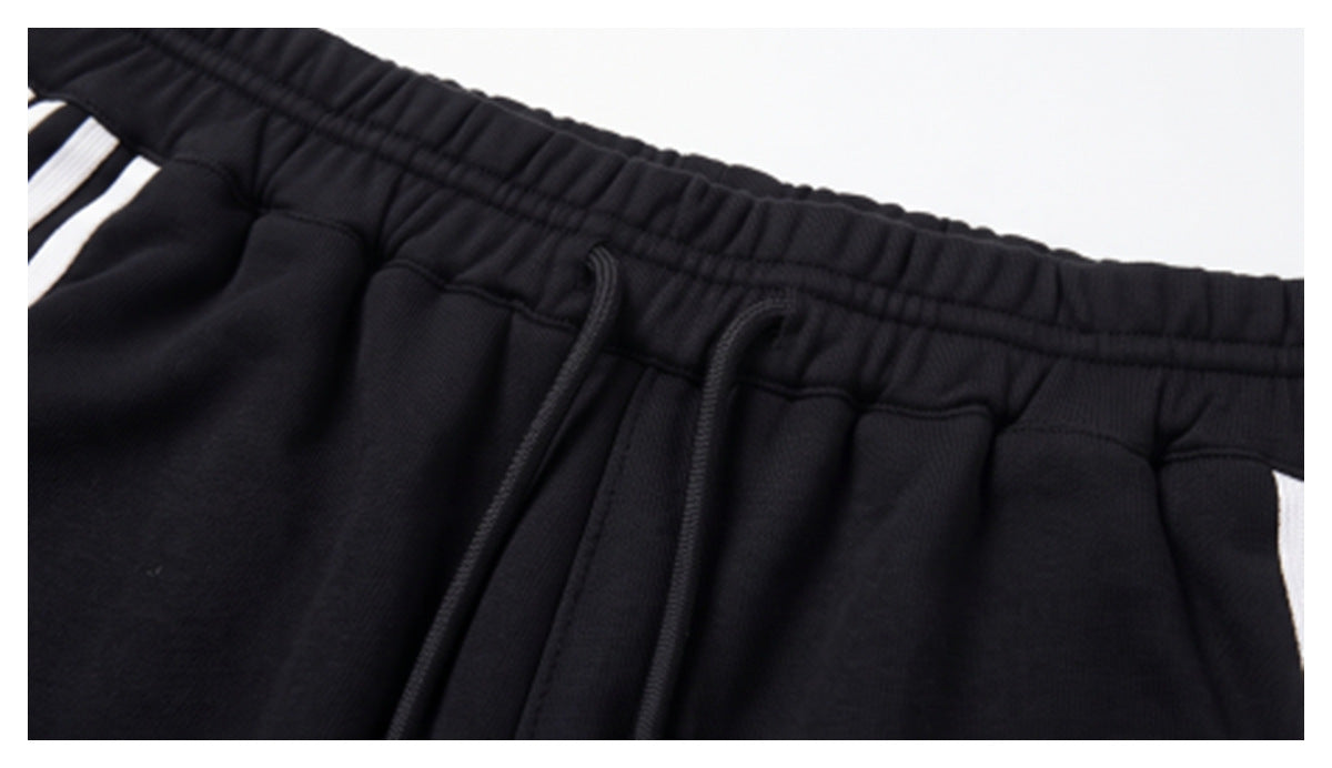Close-up of the black elastic waistband and drawstrings, with partial white side stripes visible.