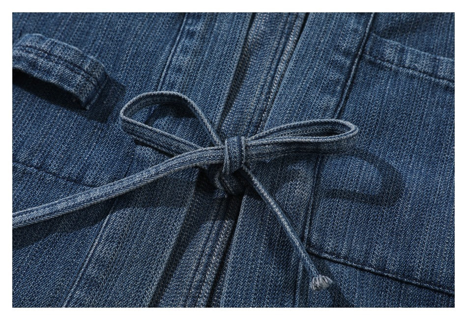 Close-up of a tied denim drawstring at the waist of a dark blue garment.