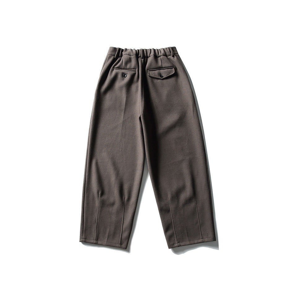 Back view of dark taupe wide-leg trousers with an elasticated waist and two buttoned back pockets.