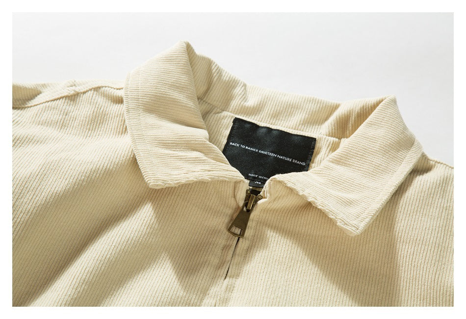 Close-up of a cream ribbed jacket collar, zipper, and black sewn-in label.