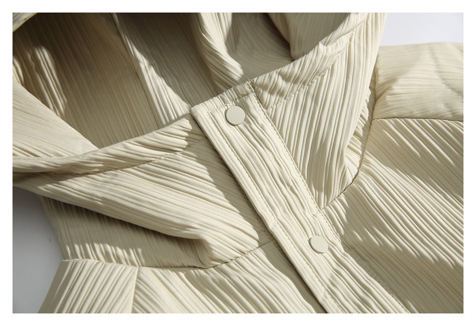 Close-up of the ivory pleated hood edge and snap-button placket.