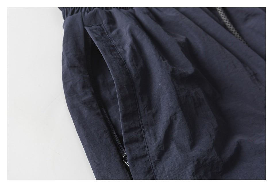 Close-up of dark navy pants showing a side pocket with a concealed zipper.