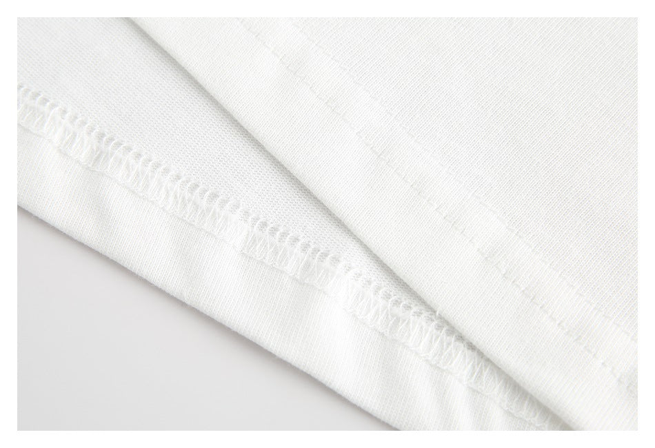 Close-up of white fabric showing an overlocked seam and stitching.
