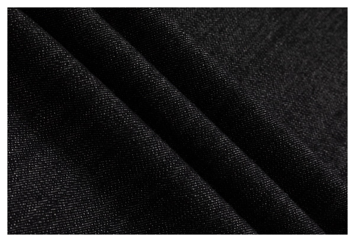 Close-up of dark charcoal-black fabric with a fine, subtly speckled woven texture and soft folds.