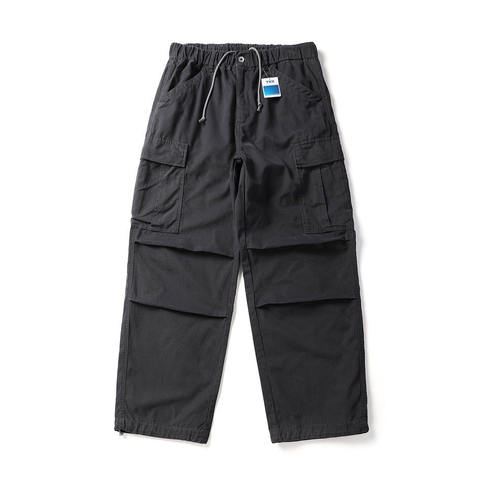 Dark charcoal wide-leg cargo pants flat lay with drawstring waist, flap cargo pockets and pleated knees