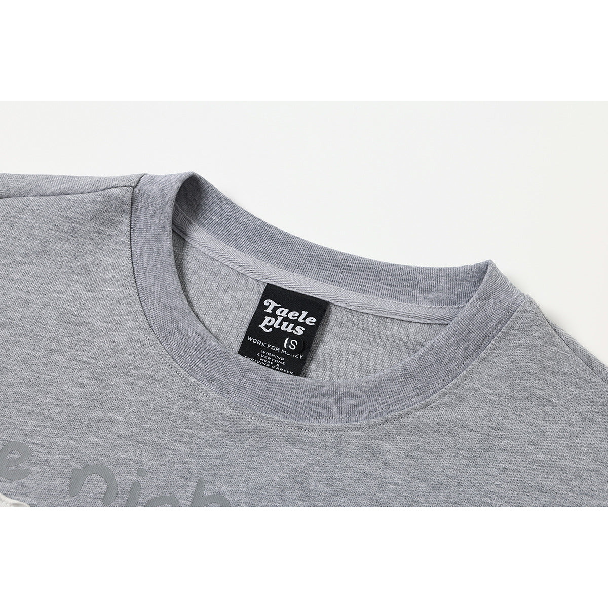 Close-up of a gray crew-neck shirt collar with a black neck label.