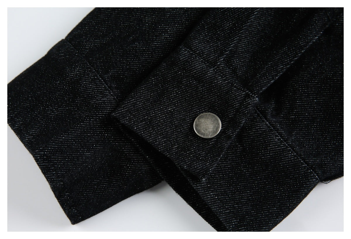 Close-up of a round metal snap fastener on a black fabric tab with visible stitching.