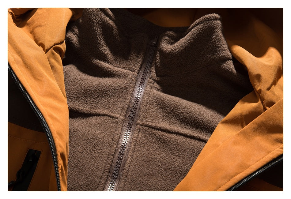 Close-up of a brown fleece-lined jacket with an orange outer shell and front zipper.