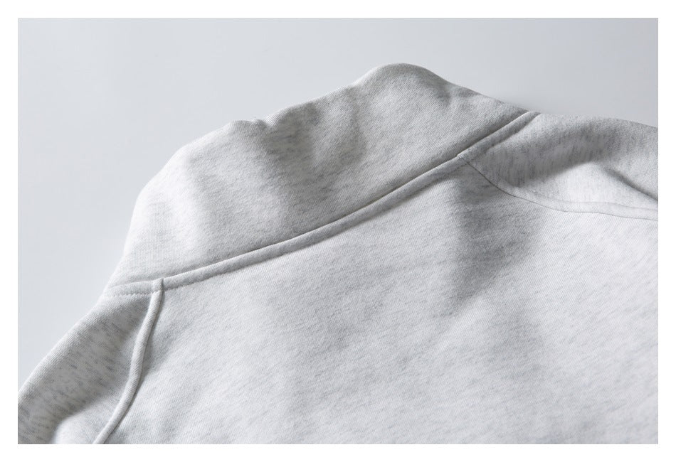 Close-up of the back collar and shoulder seams of a light gray sweatshirt.