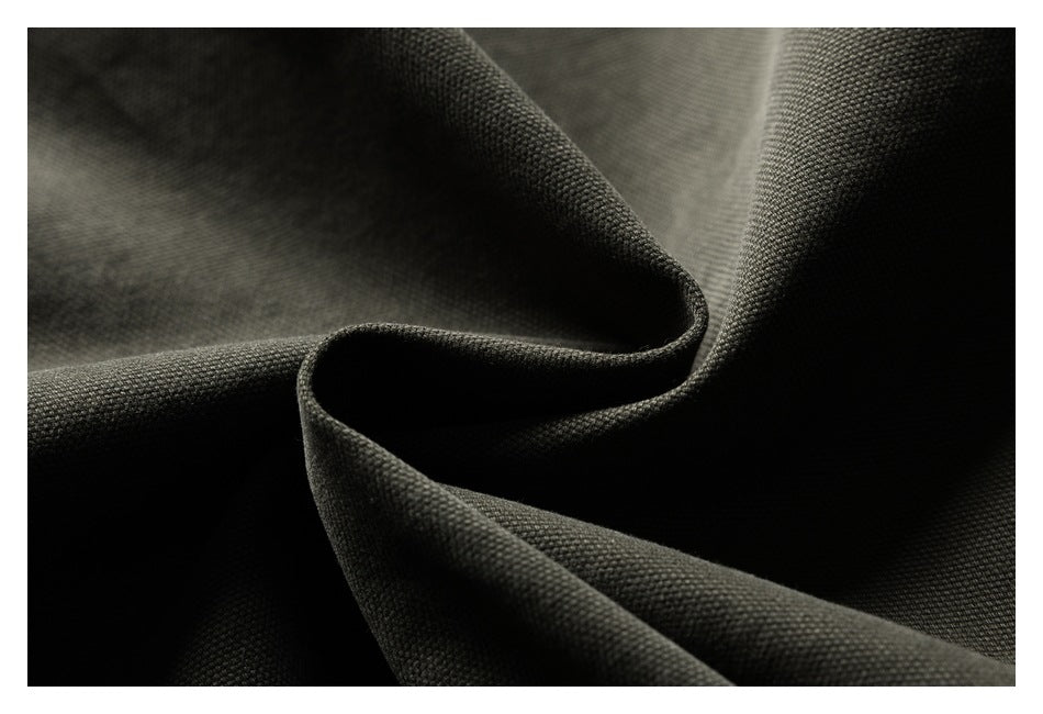 Close-up of dark charcoal woven fabric gathered into curved folds.