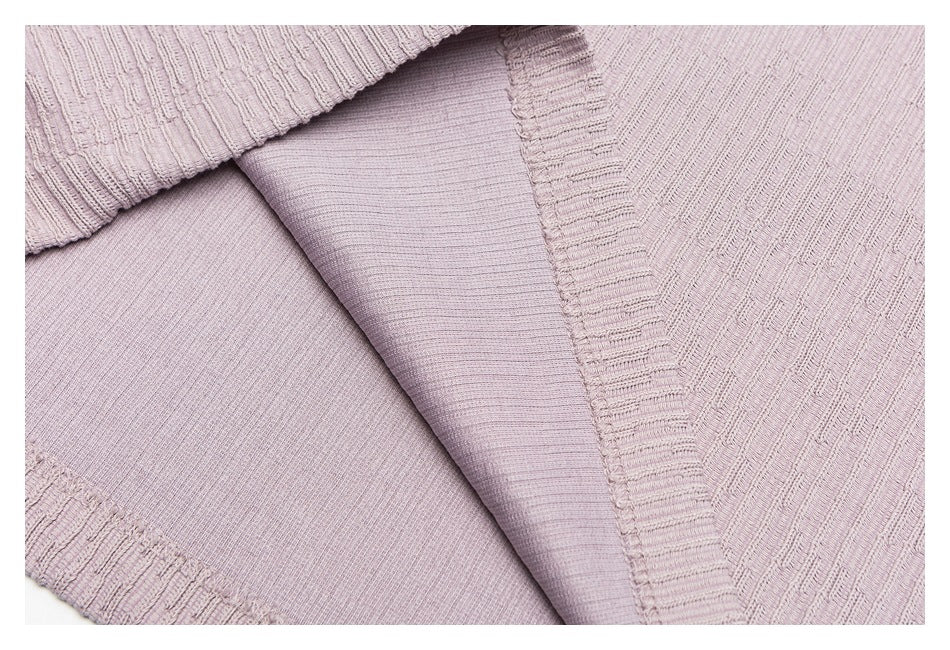 Close-up of the inside construction and smooth facing along a mauve knit top's seam.