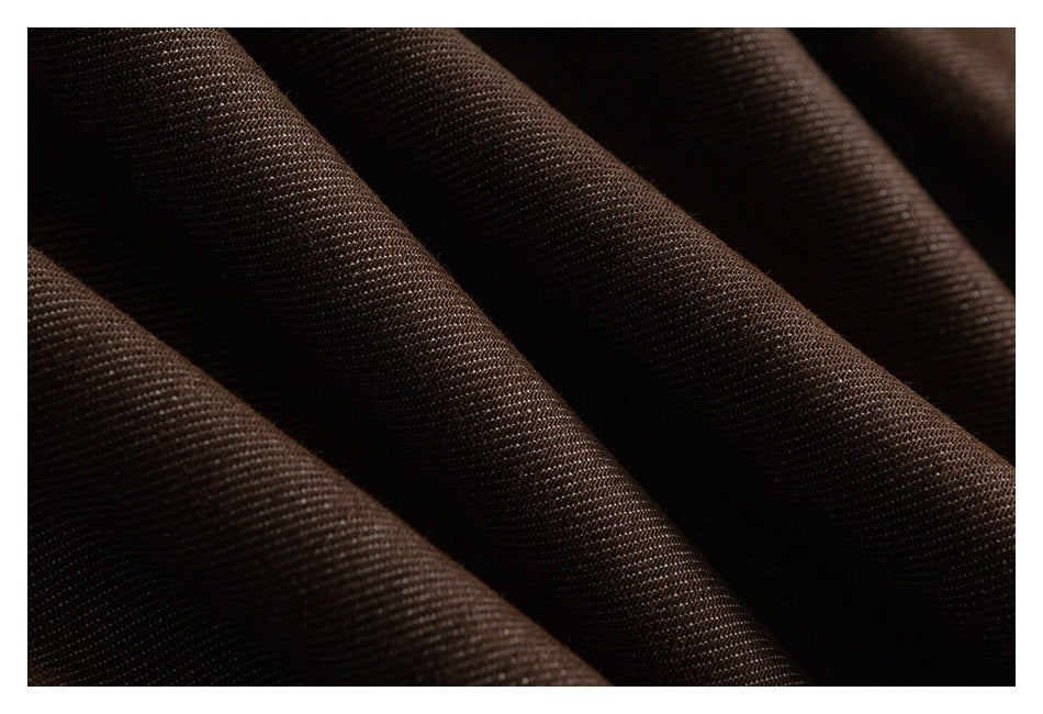 Close-up of dark brown fabric with a fine woven texture and soft folds.