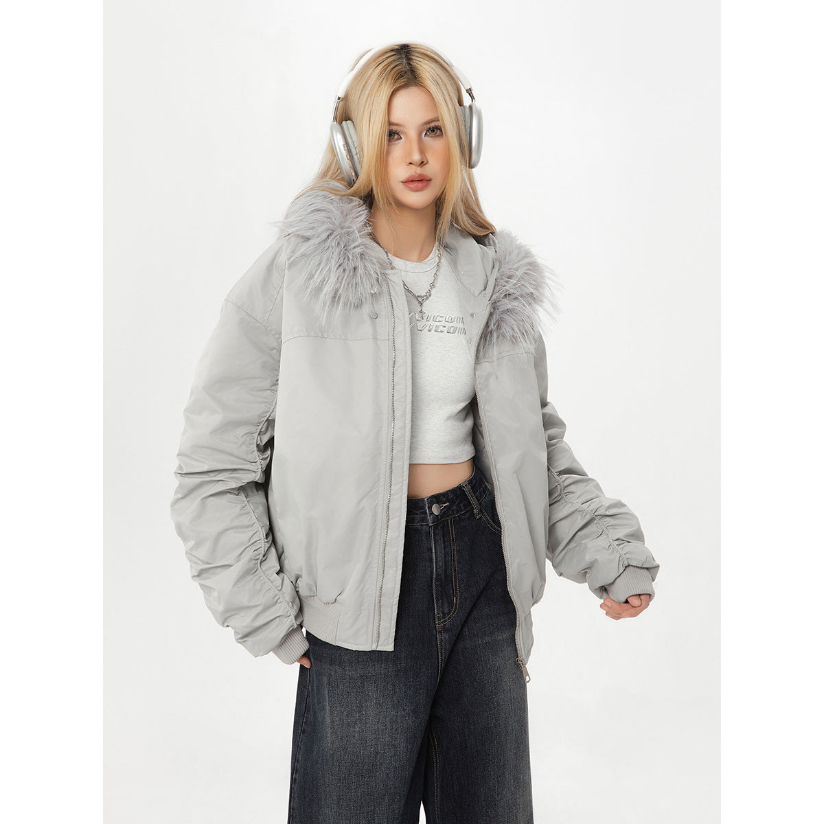 Model wearing an open light gray fur-collar jacket with gathered sleeves and dark jeans.