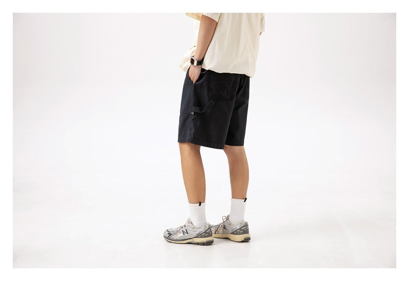 Rear three-quarter view of a model wearing black shorts with a side cargo pocket.