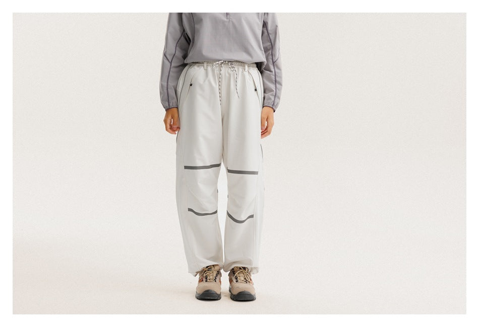 Front view of a cropped model wearing loose off-white drawstring pants with dark bands across the knees and lower legs.