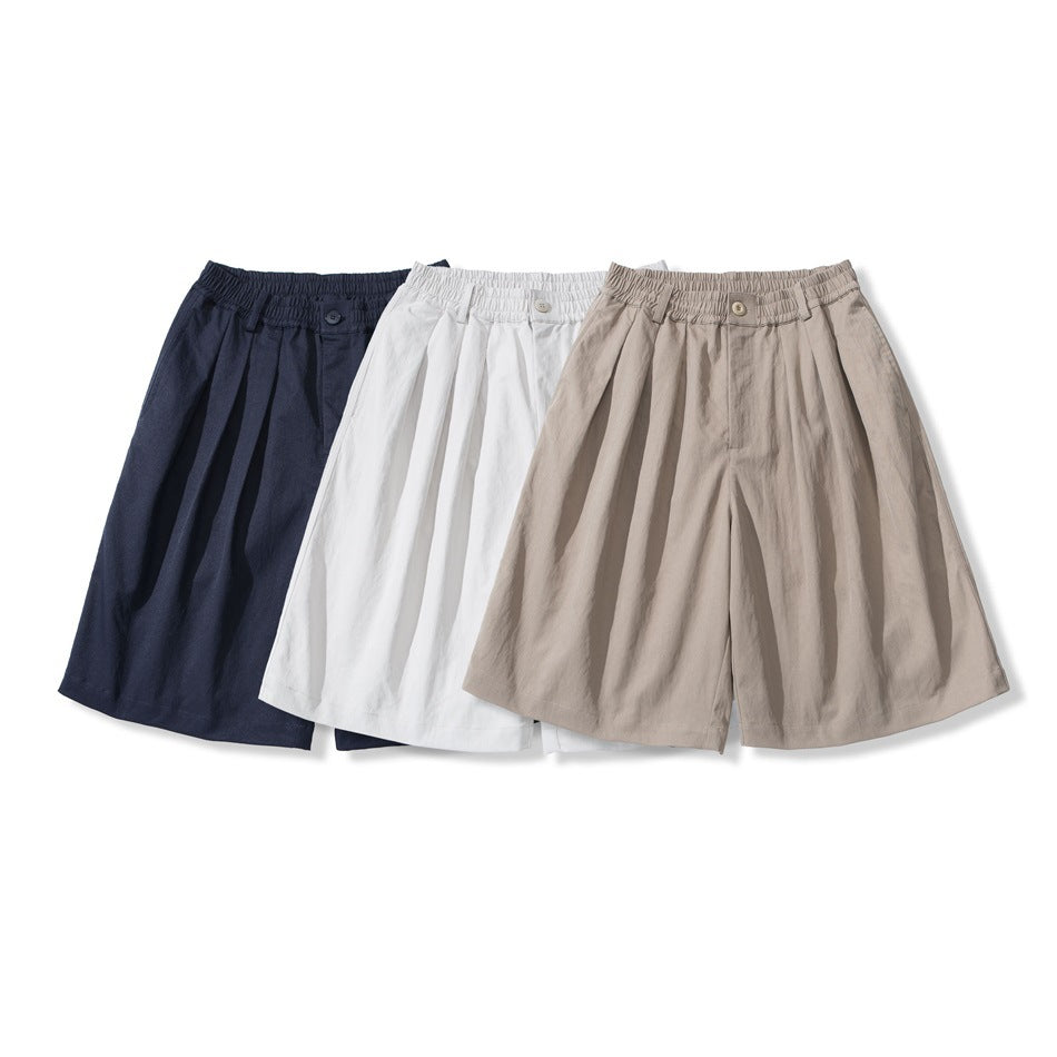 Three pairs of wide-leg shorts shown together in navy, white and taupe, with elastic waistbands and front pleats.