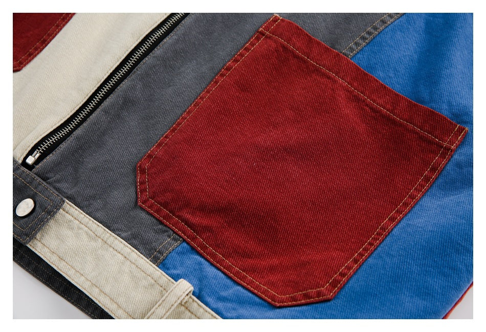 Close-up of a burgundy patch pocket on blue and charcoal color-block jacket panels.
