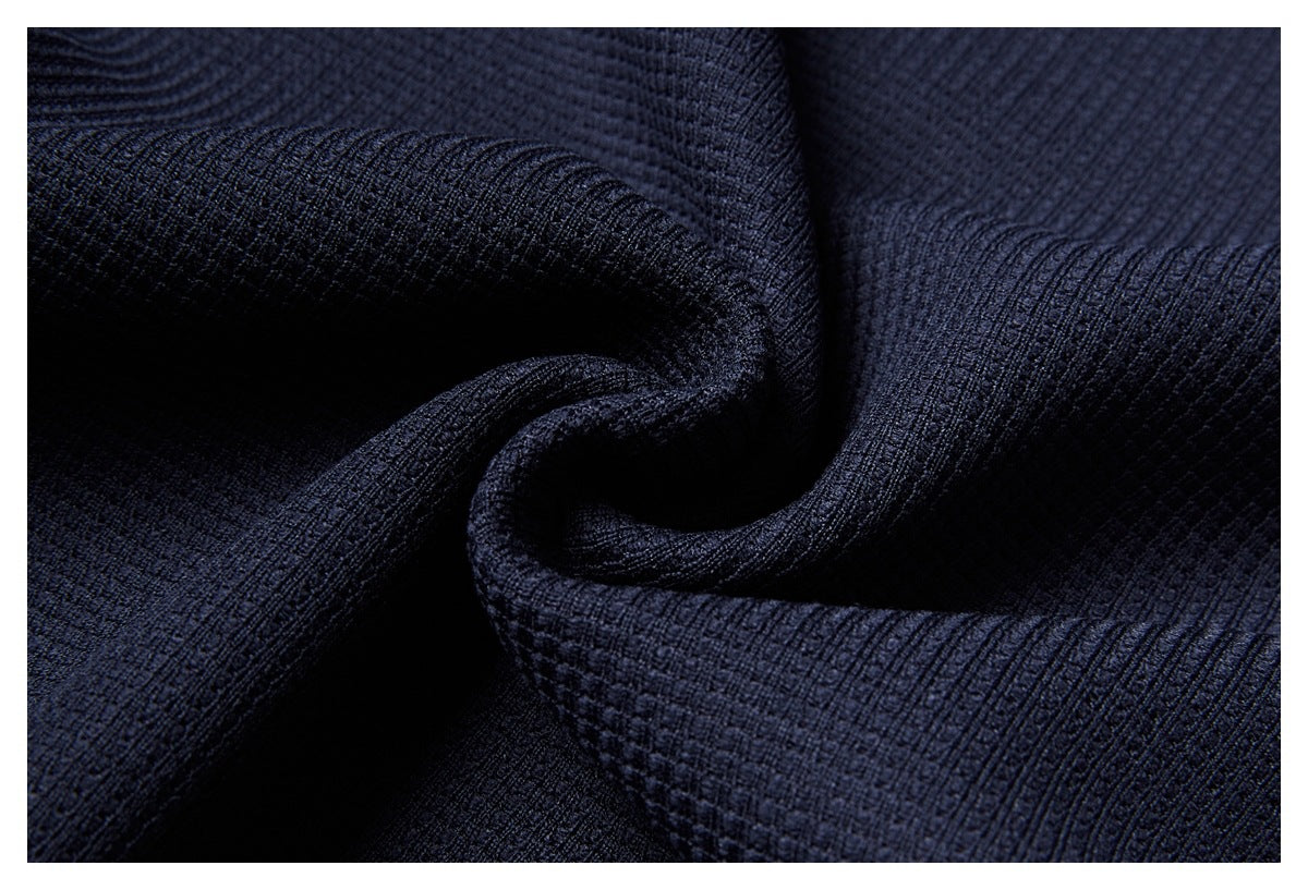Close-up of dark navy textured fabric gathered into folds.