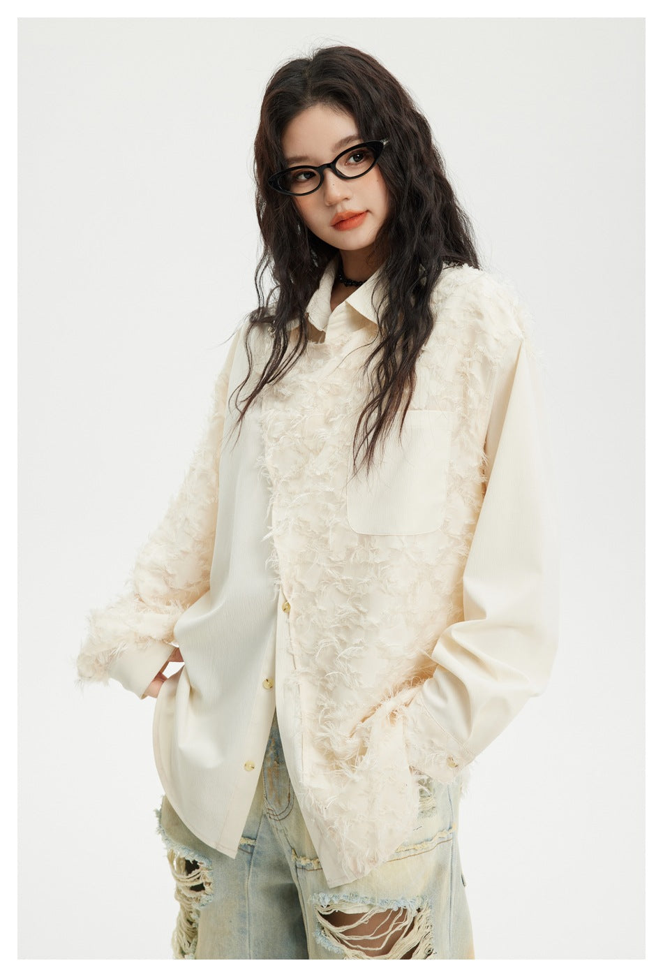Model wearing an ivory textured button-up shirt with a chest pocket and distressed light-wash jeans, front view.
