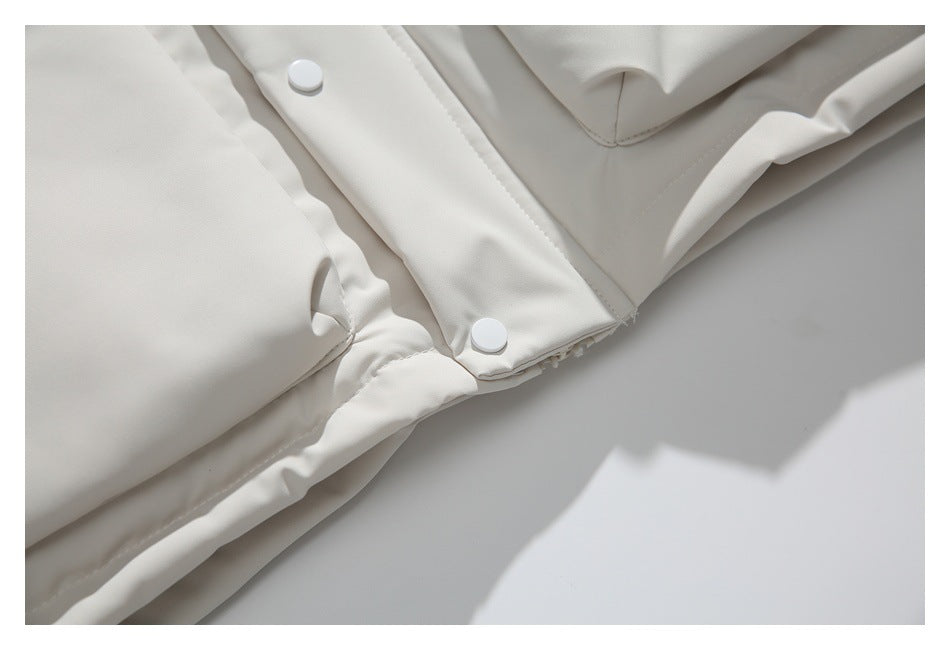 Close-up of the ivory jacket’s lower front, showing a pocket corner and white snap buttons.