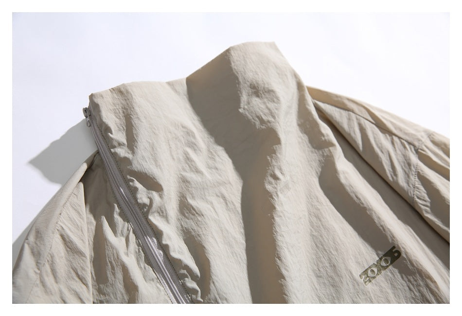 Close-up of the beige jacket's high collar and curved zipper panel.