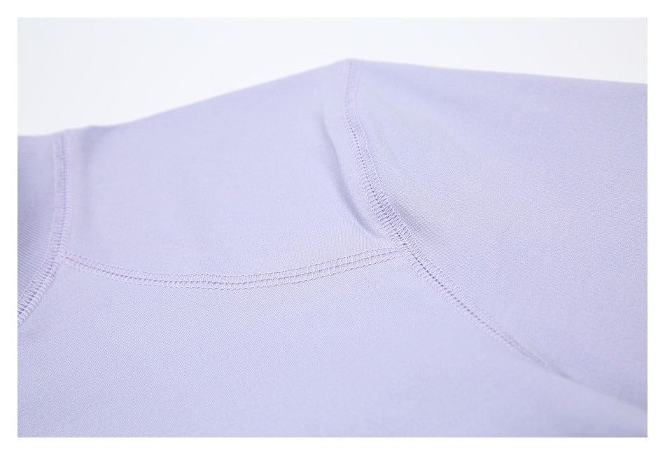 Close-up of curved seam stitching across the shoulder and sleeve of the lavender shirt.