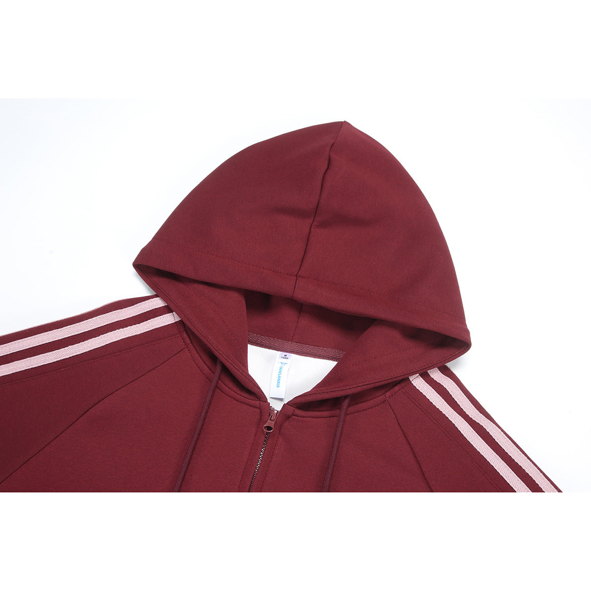Close-up of a burgundy zip-up hoodie showing its hood, drawstrings, zipper and pale sleeve stripes.