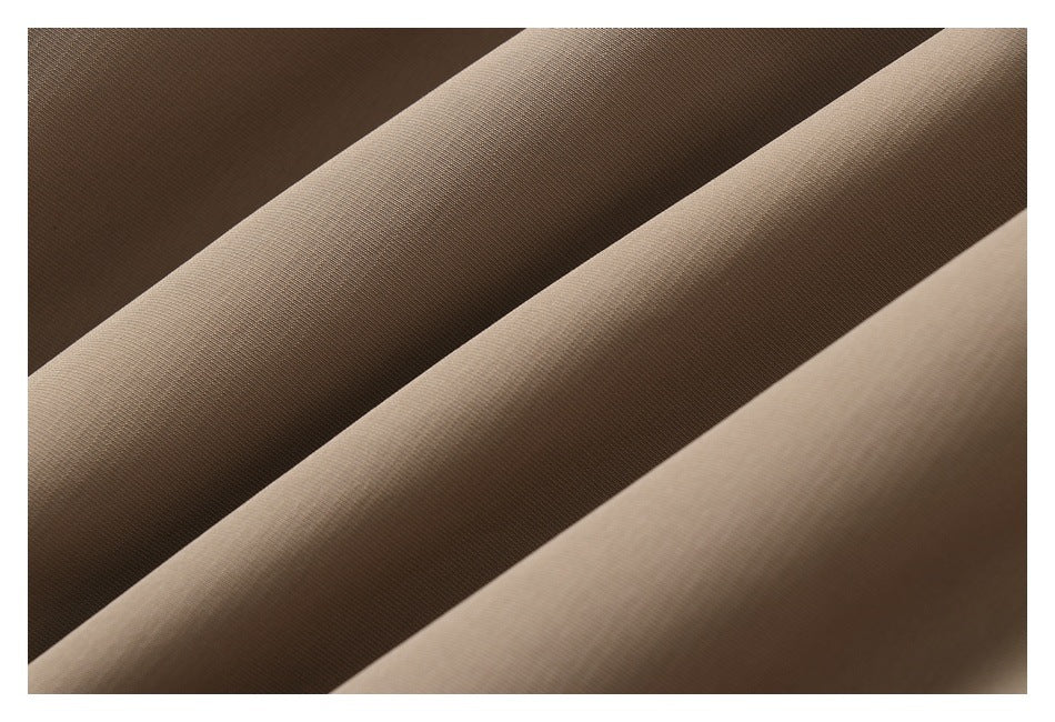 Macro view of beige fabric arranged in folds, showing its fine surface texture.