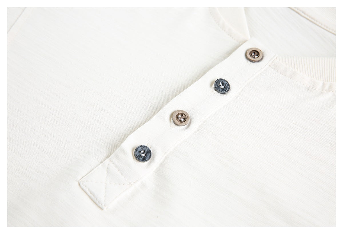Close-up of an ivory shirt's short placket with four alternating dark and brown buttons.